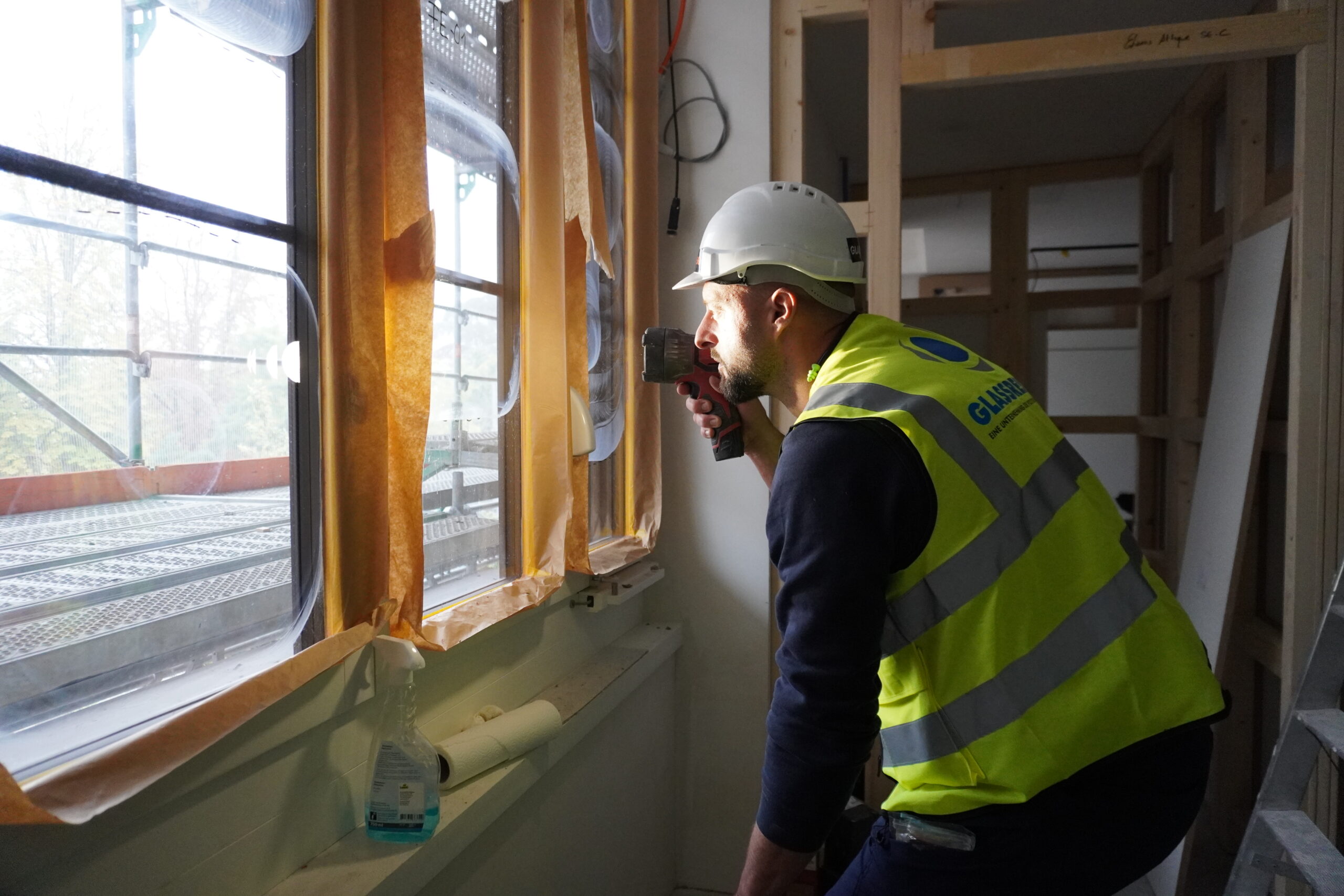 Oberflächenbeurteilung-Sichtpruefung-GLASSRESQ Facharbeiter fuehrt Sichtpruefung beim Kratzer im Glas durch